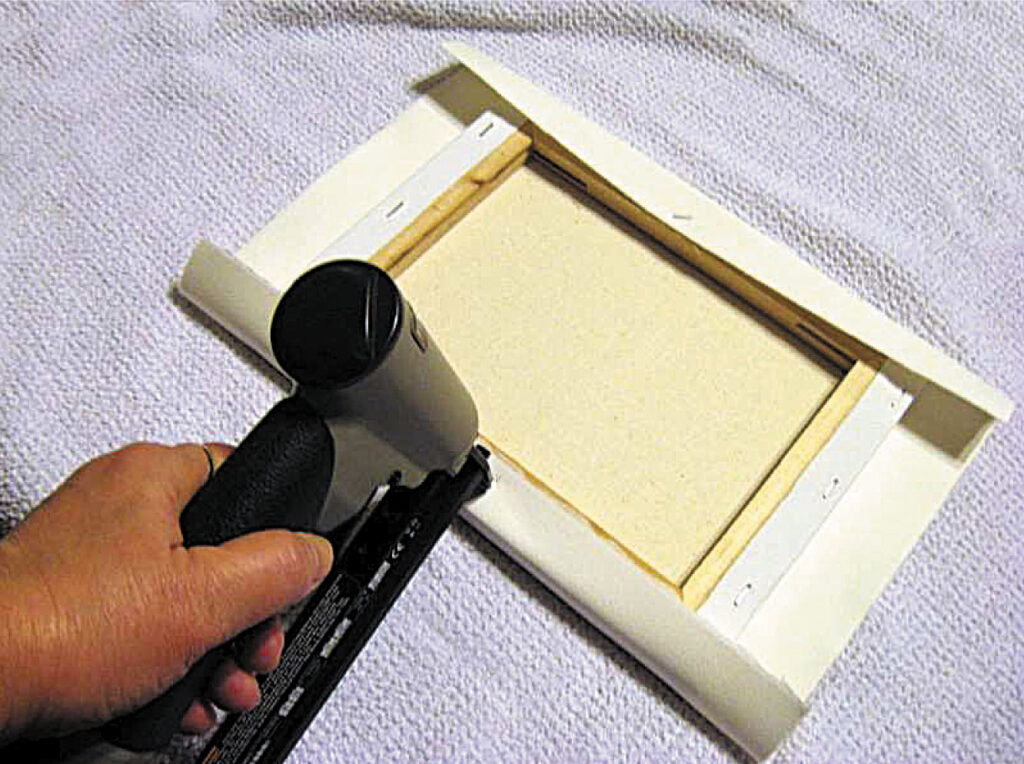 stapling-the-side-stretching-watercolour-paper-over-a-canvas-aotearoa-artist